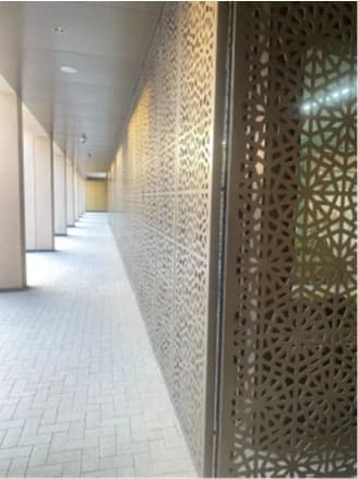 Perforated architectural screen along a walkway at Misk School